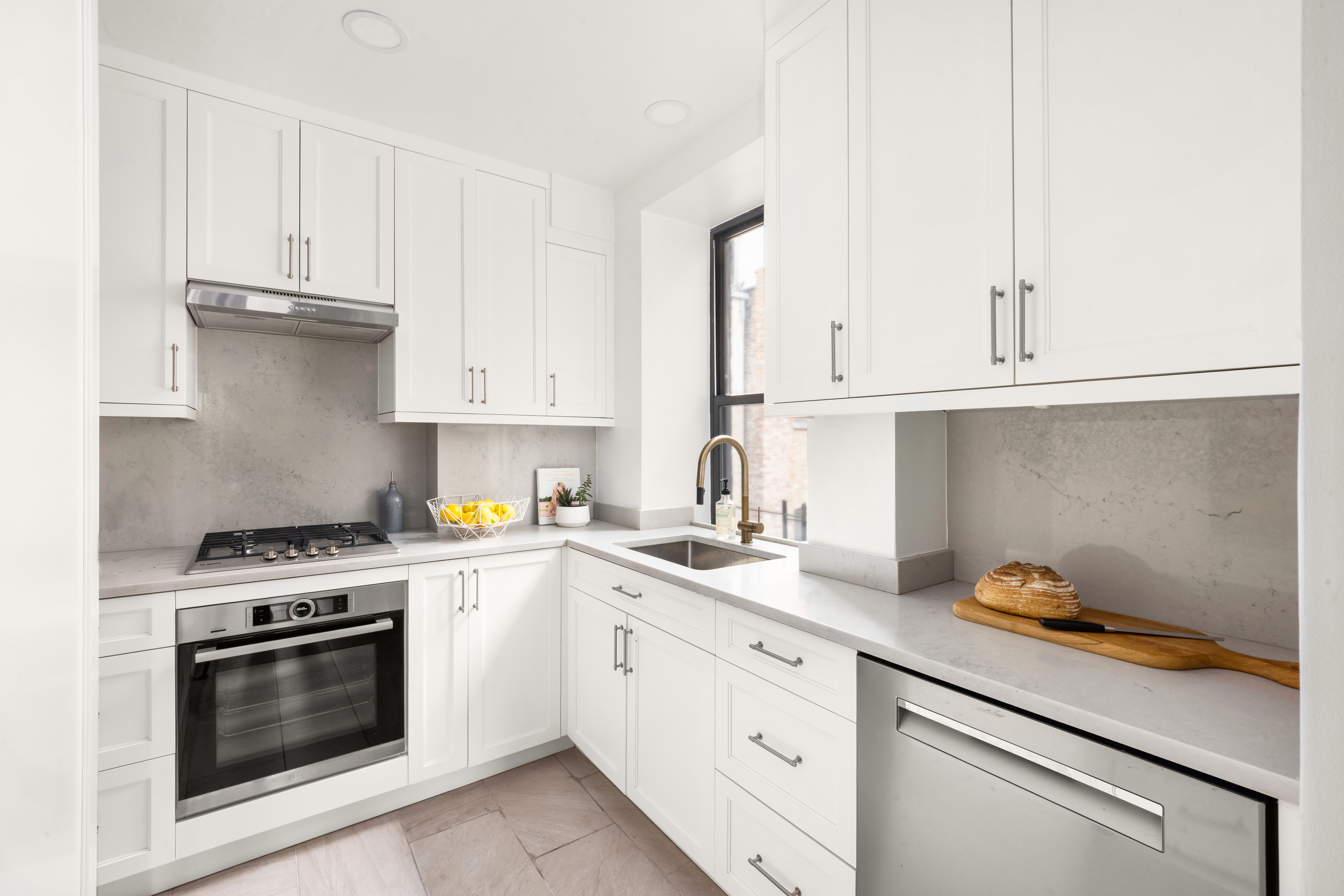 119 West 71st Street, Unit 9B Manhattan, NY 10023 - Photo 7 of 18 a kitchen with granite countertop white cabinets and white appliances