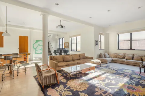 a living room with furniture a rug and a large window
