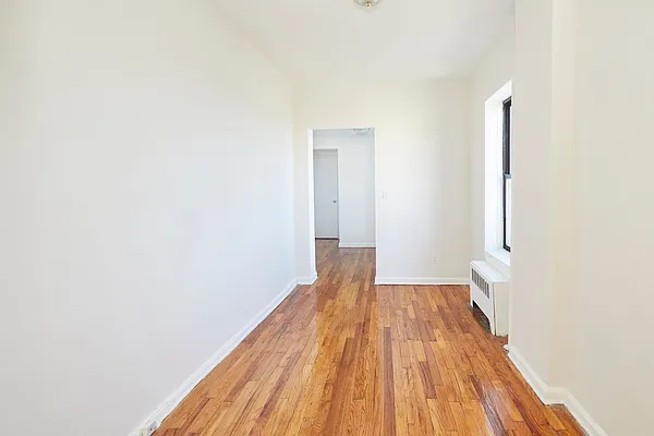 506 West 145th Street, Unit 4D Manhattan, NY 10031 - Photo 1 of 9 a view of a room with wooden floor and bench
