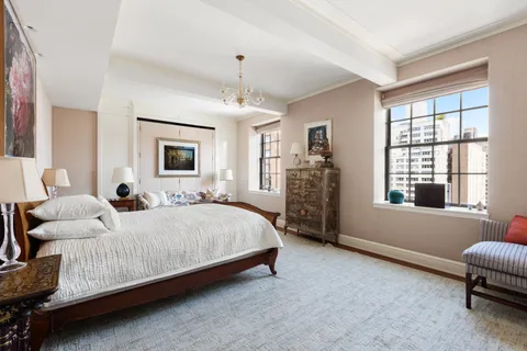 a spacious bedroom with a bed couch and a window