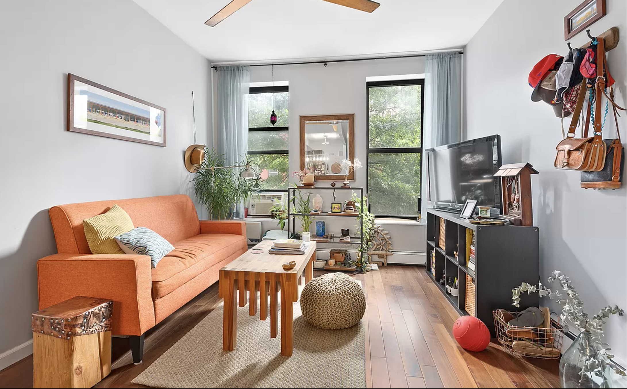 a living room with furniture a flat screen tv and a floor to ceiling window