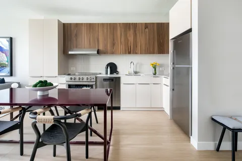 a kitchen with stainless steel appliances granite countertop a table chairs sink and cabinets