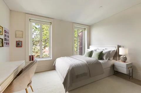 a bed sitting in a bedroom next to a window