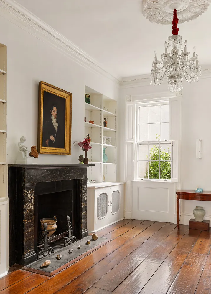 a living room with a fireplace and chandelier