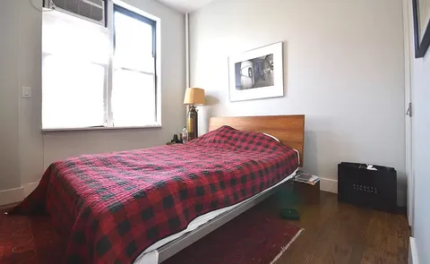 a bedroom with a bed and a window