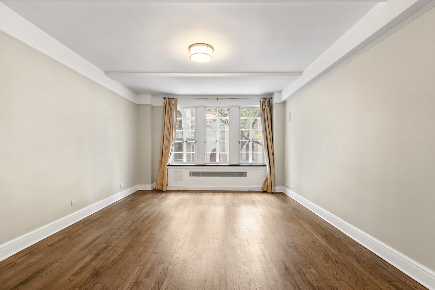 110 East 87th Street, Unit 2C Manhattan, NY 10128 - Photo 9 of 13 an empty room with wooden floor and windows