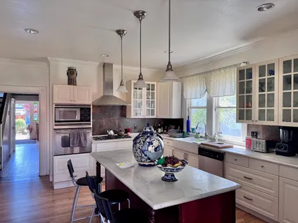 a kitchen with sink a stove and chairs