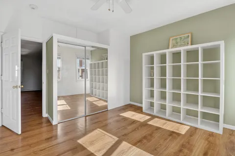 a view of empty room with wooden floor and windows