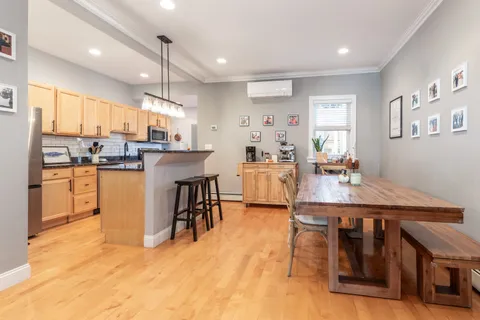 a room with stainless steel appliances kitchen island granite countertop furniture wooden floor and a kitchen view