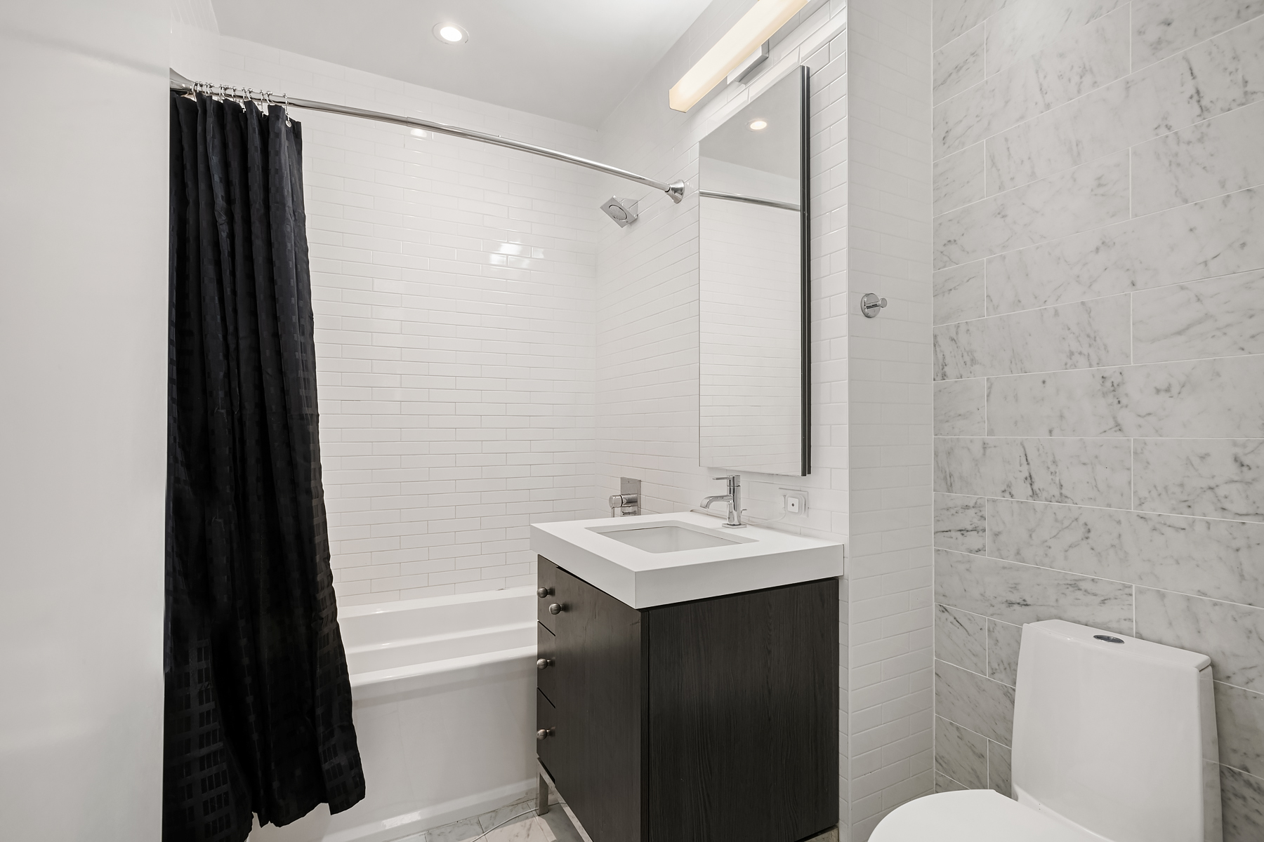 416 West 52nd Street, Unit 725 Manhattan, NY 10019 - Photo 6 of 15 a bathroom with a sink a toilet a mirror and shower