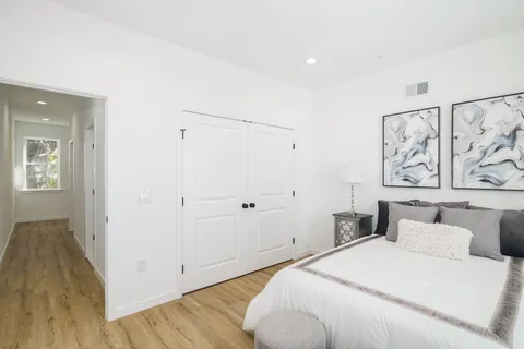 a bedroom with a bed and painting on the wall