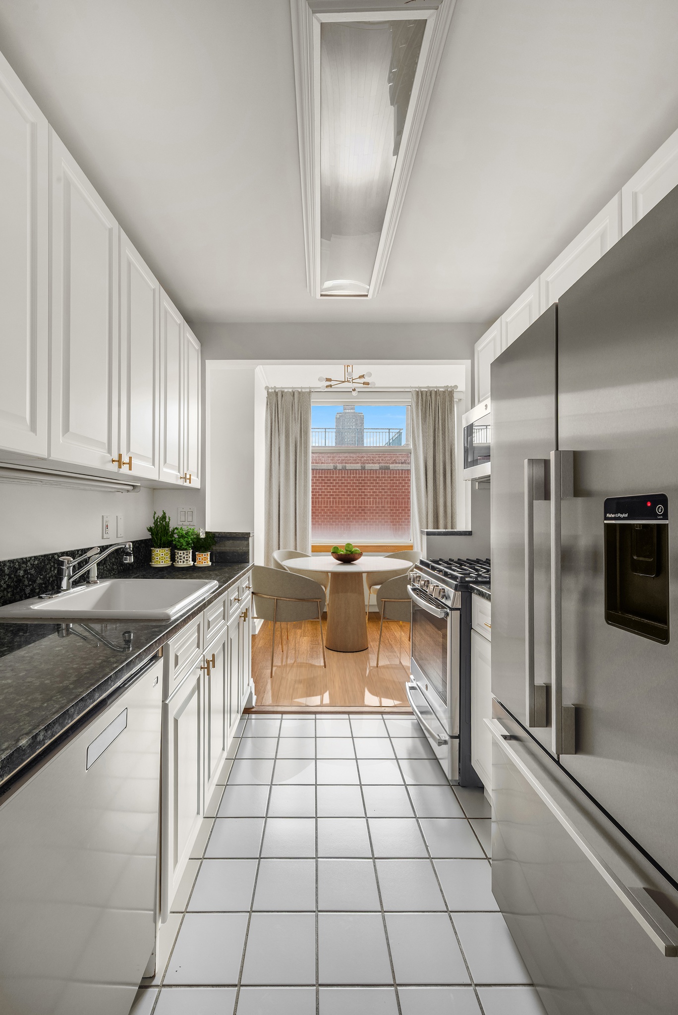 404 East 76th Street, Unit 7D Manhattan, NY 10021 - Photo 4 of 12 a large kitchen with a large counter top appliances and cabinets