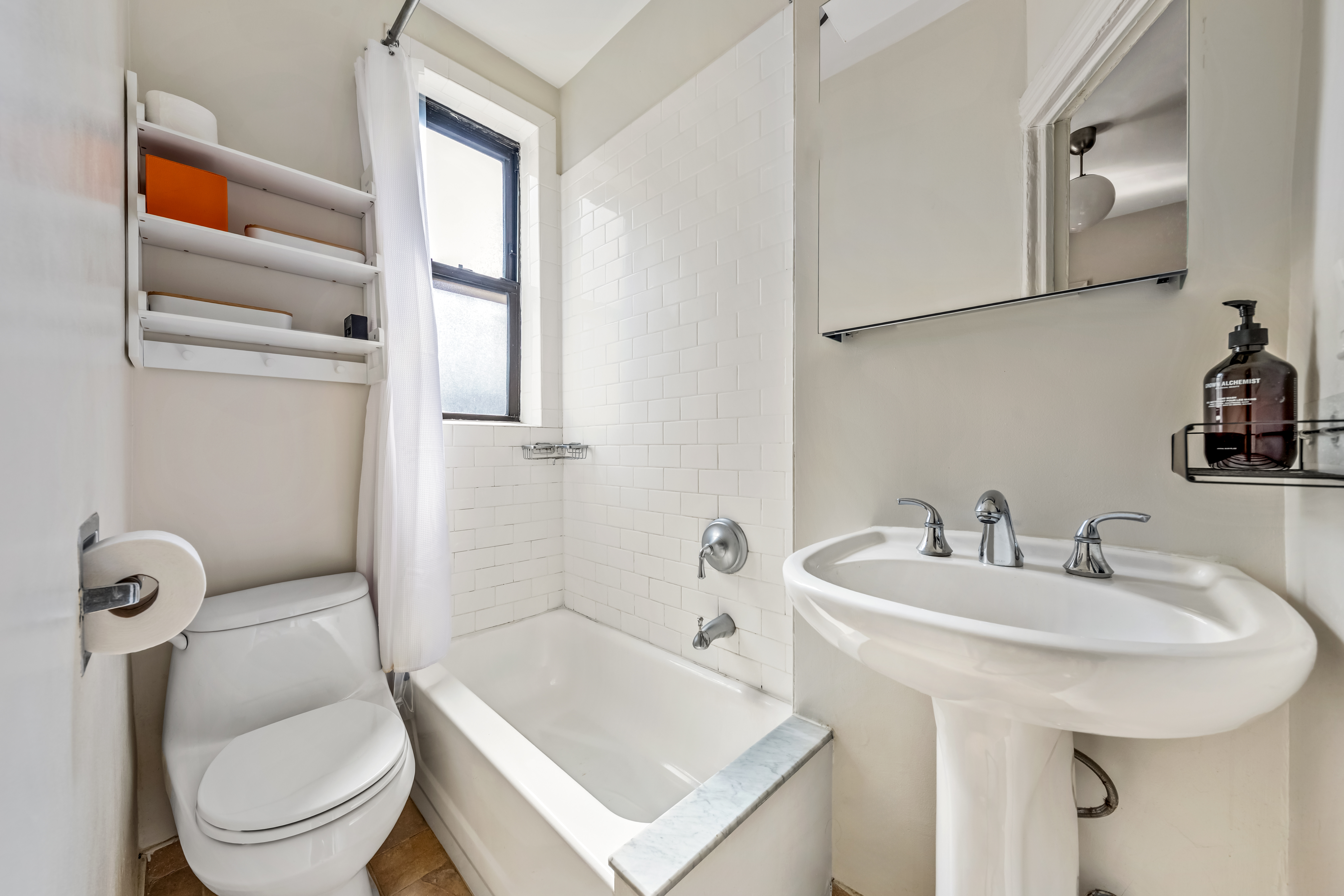 411 West 44th Street, Unit 13 Manhattan, NY 10036 - Photo 6 of 8 a bathroom with a sink a toilet and shower