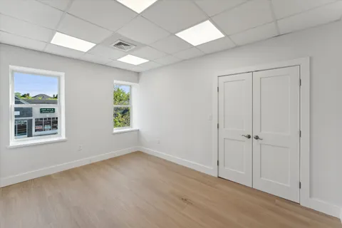 an empty room with wooden floor and windows