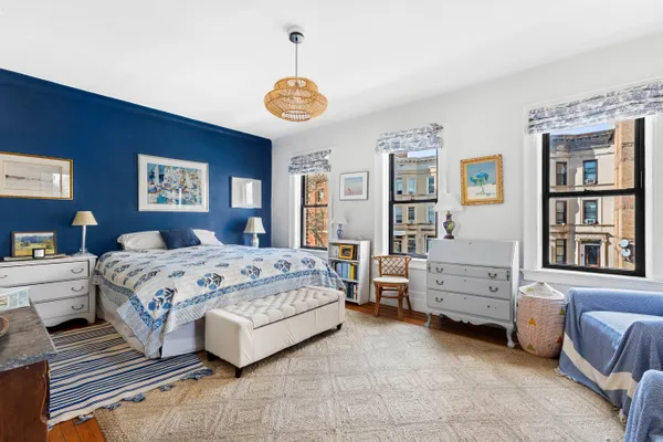 a spacious bedroom with a bed and a chandelier