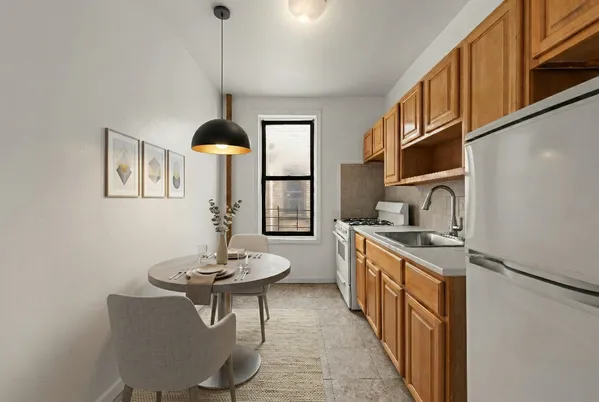 a kitchen with stainless steel appliances kitchen island a table chairs in it and wooden floors