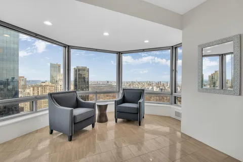 a living room with furniture and a floor to ceiling window