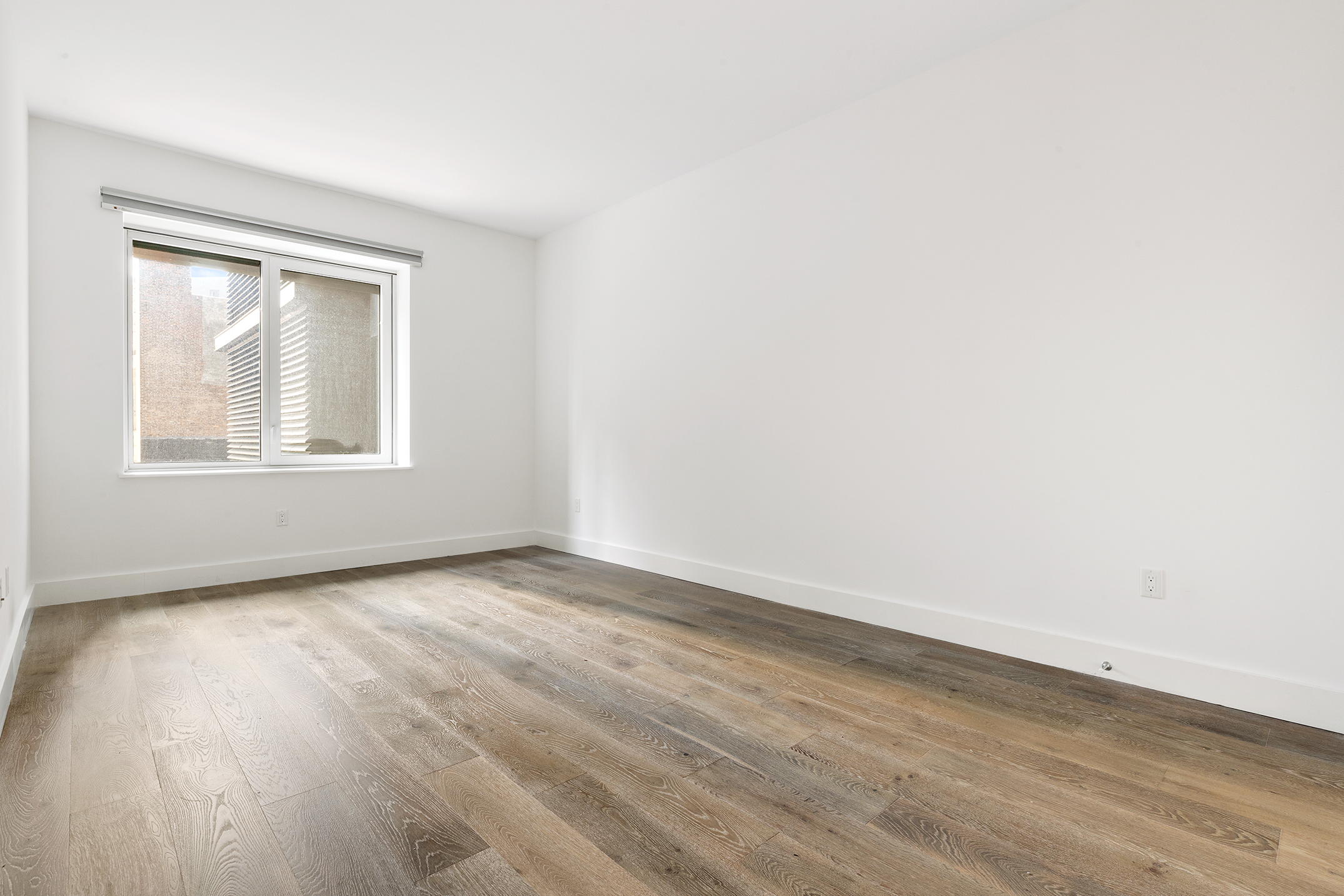 10 Nevins Street, Unit 5M Brooklyn, NY 11217 - Photo 2 of 7 an empty room with wooden floor and windows