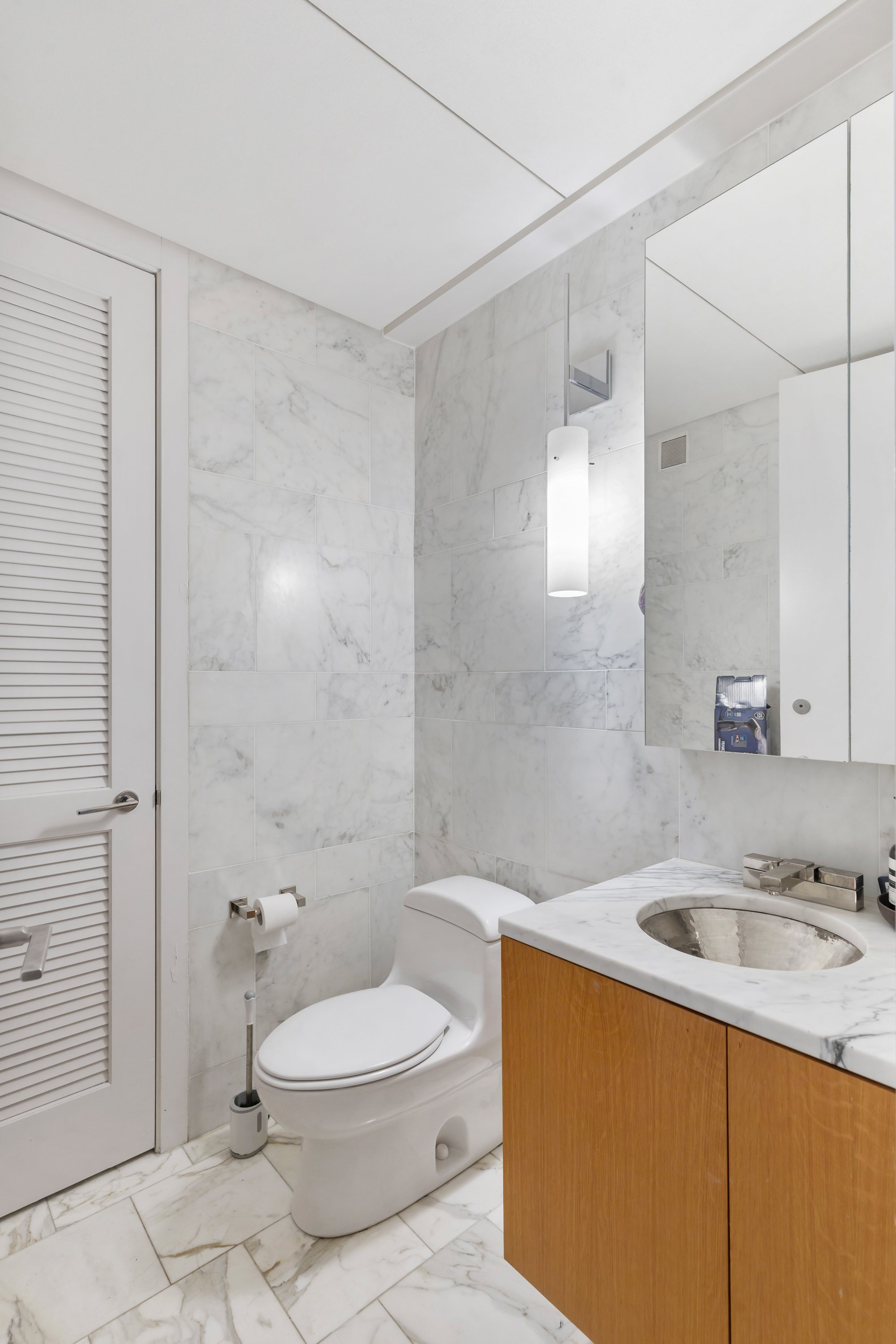 18 West 48th Street, Unit 12E Manhattan, NY 10036 - Photo 5 of 10 a bathroom with a sink a toilet and shower