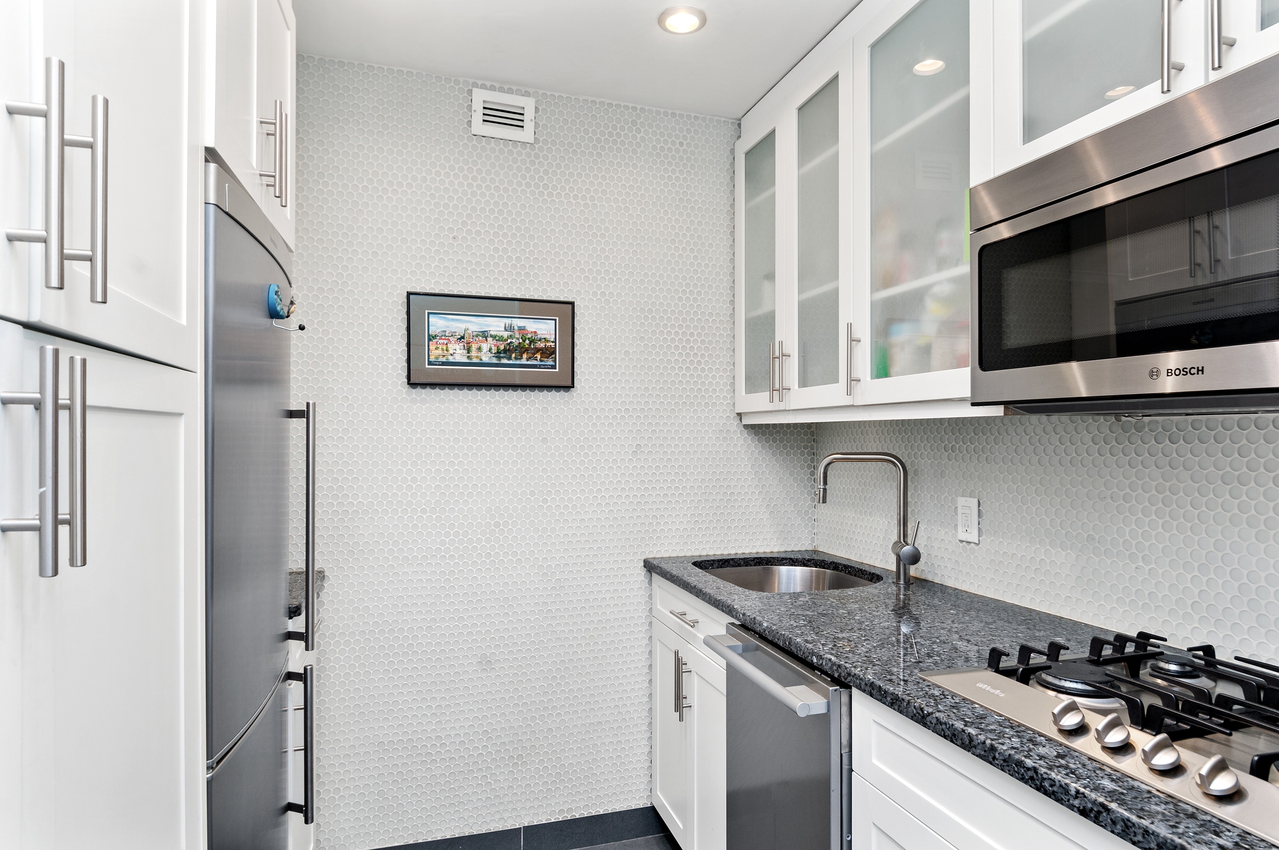10 Christopher Street, Unit 4B Manhattan, NY 10014 - Photo 3 of 6 a kitchen with stainless steel appliances granite countertop a stove a sink and a microwave