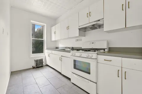 a kitchen with cabinets appliances and a window