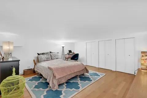 a bedroom with a bed and wooden floor