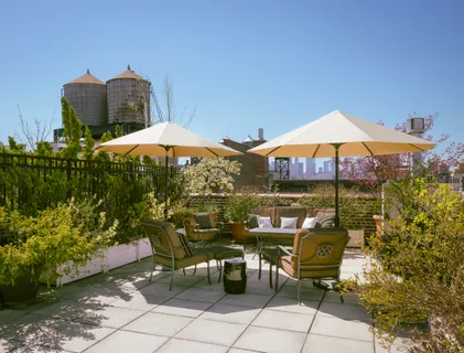 a view of a patio with chairs under an umbrella