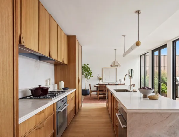 a kitchen with kitchen island granite countertop a sink a counter top space and cabinets