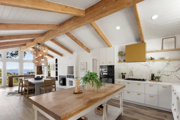 a kitchen with stainless steel appliances granite countertop a stove a sink dishwasher and white cabinets with wooden floor