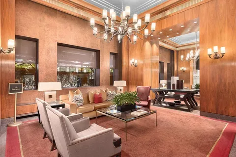 a living room with furniture a chandelier and a dining table