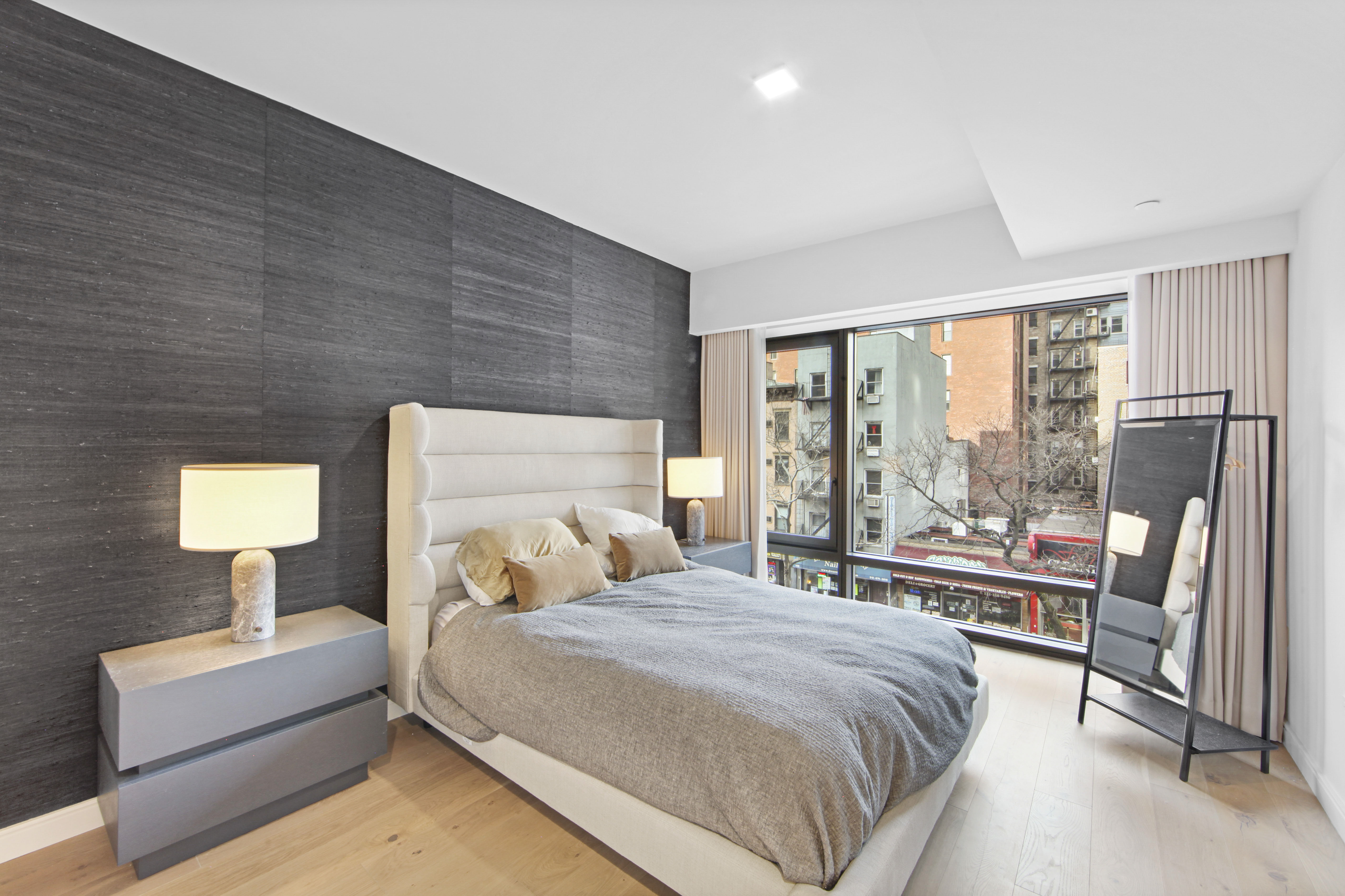 200 East 21st Street, Unit 4B Manhattan, NY 10010 - Photo 9 of 15 a bedroom with a large bed and a lamp