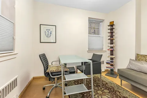 a work room with furniture wooden floor and windows
