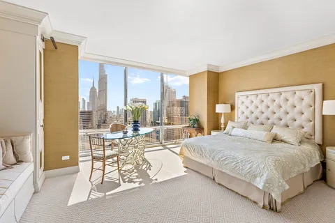 a spacious bedroom with a bed and large windows