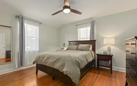 a bedroom with a bed wooden floor and a window