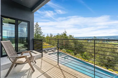 a view of a balcony with wooden floor next to a yard