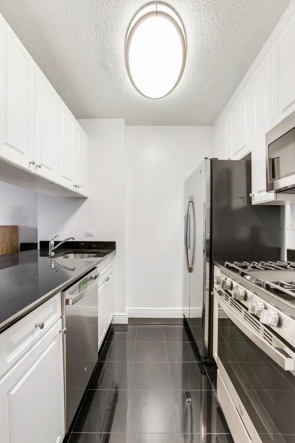 a kitchen with stainless steel appliances granite countertop a stove and a refrigerator