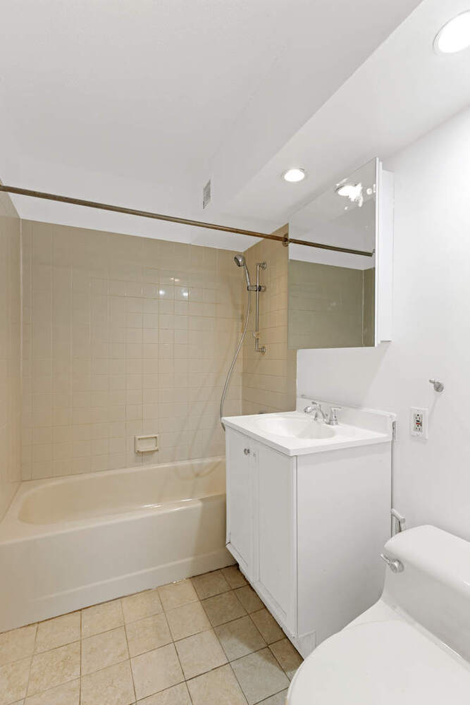 376 Broadway, Unit 6F Manhattan, NY 10013 - Photo 8 of 17 a bathroom with a sink a toilet and shower