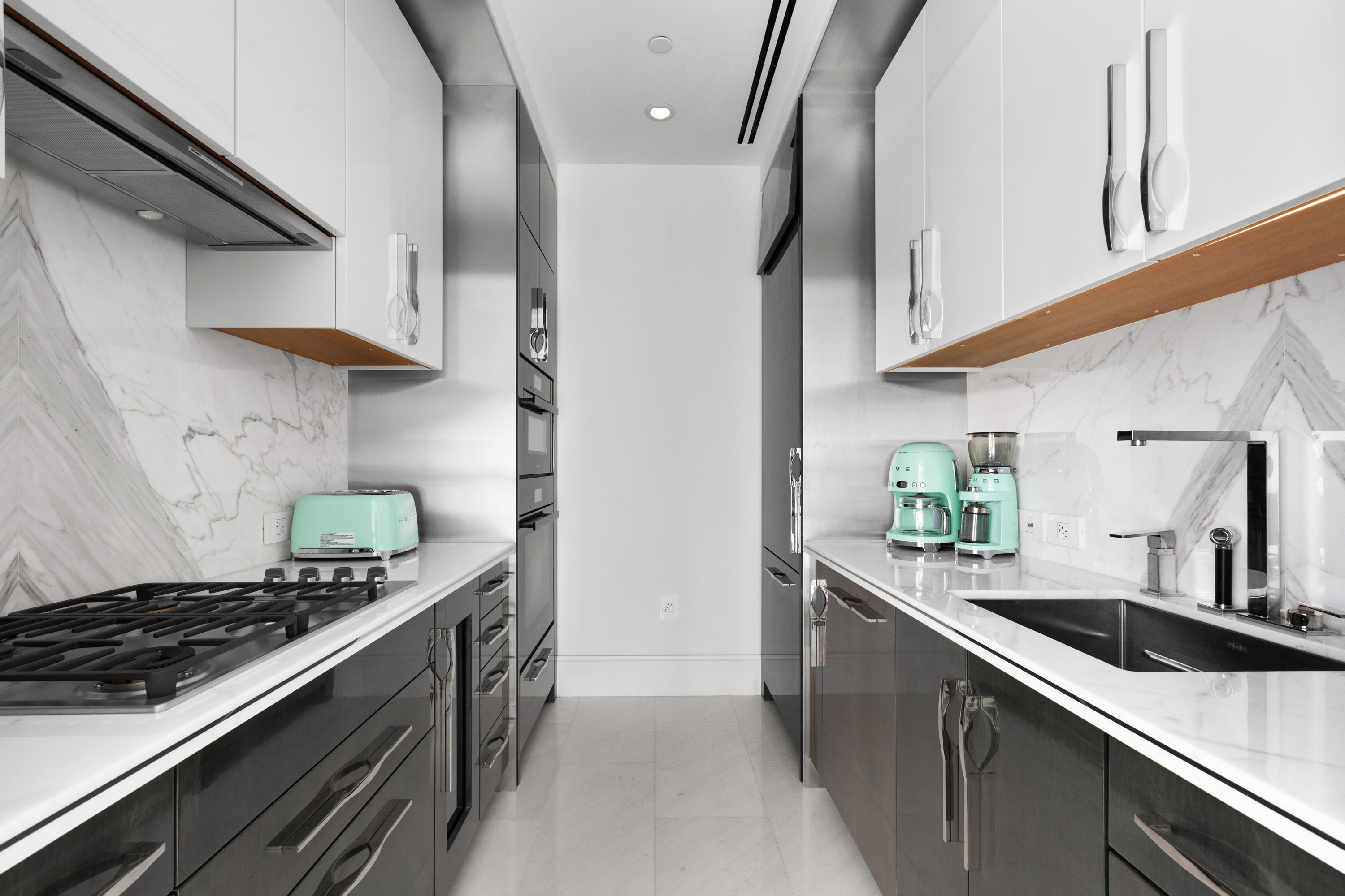 217 West 57th Street, Unit 48D Manhattan, NY 10019 - Photo 6 of 17 a kitchen with stainless steel appliances a sink stove and cabinets