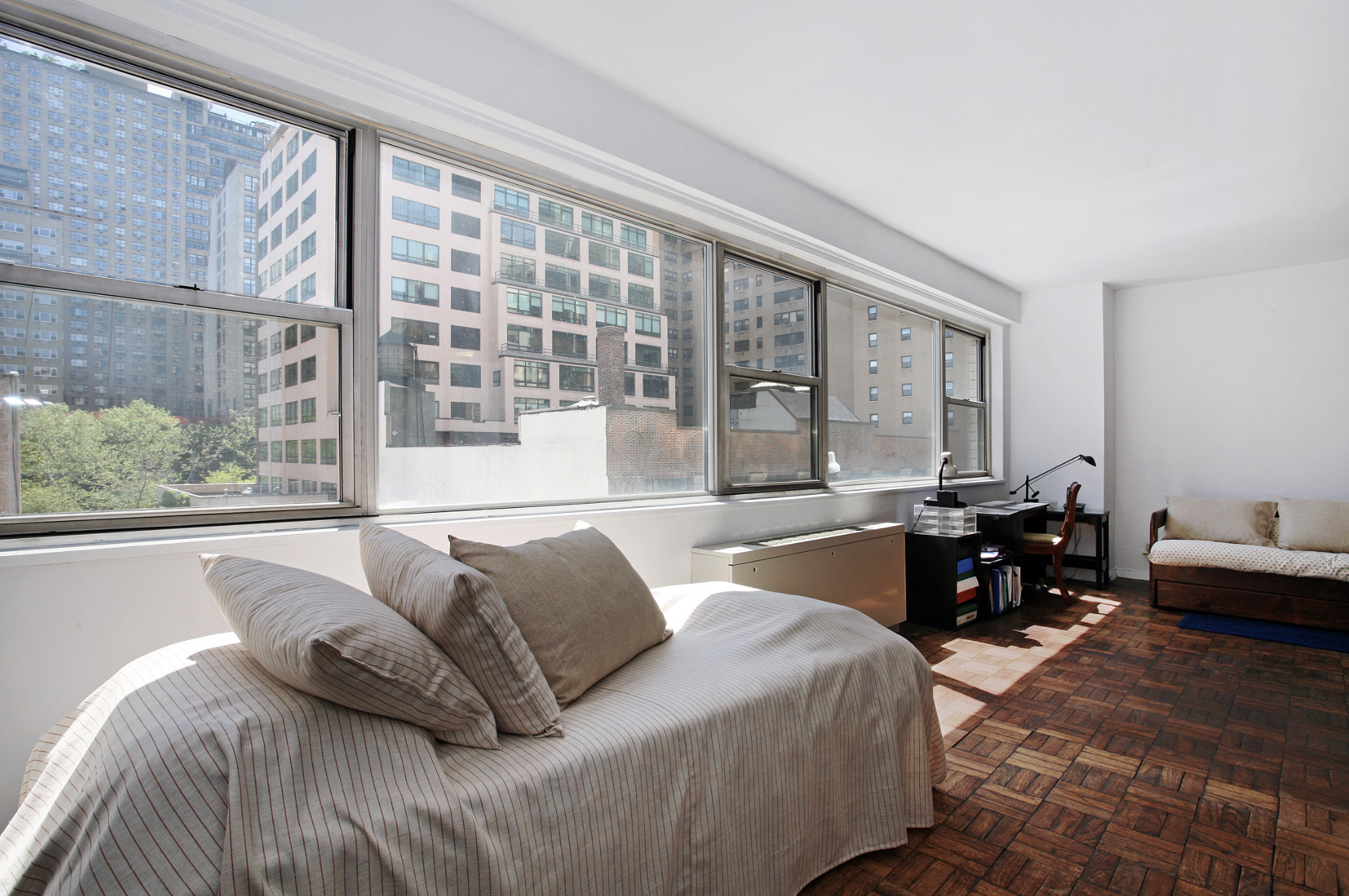 321 East 48th Street, Unit 7F Manhattan, NY 10017 - Photo 1 of 7 a bedroom with furniture and a large window