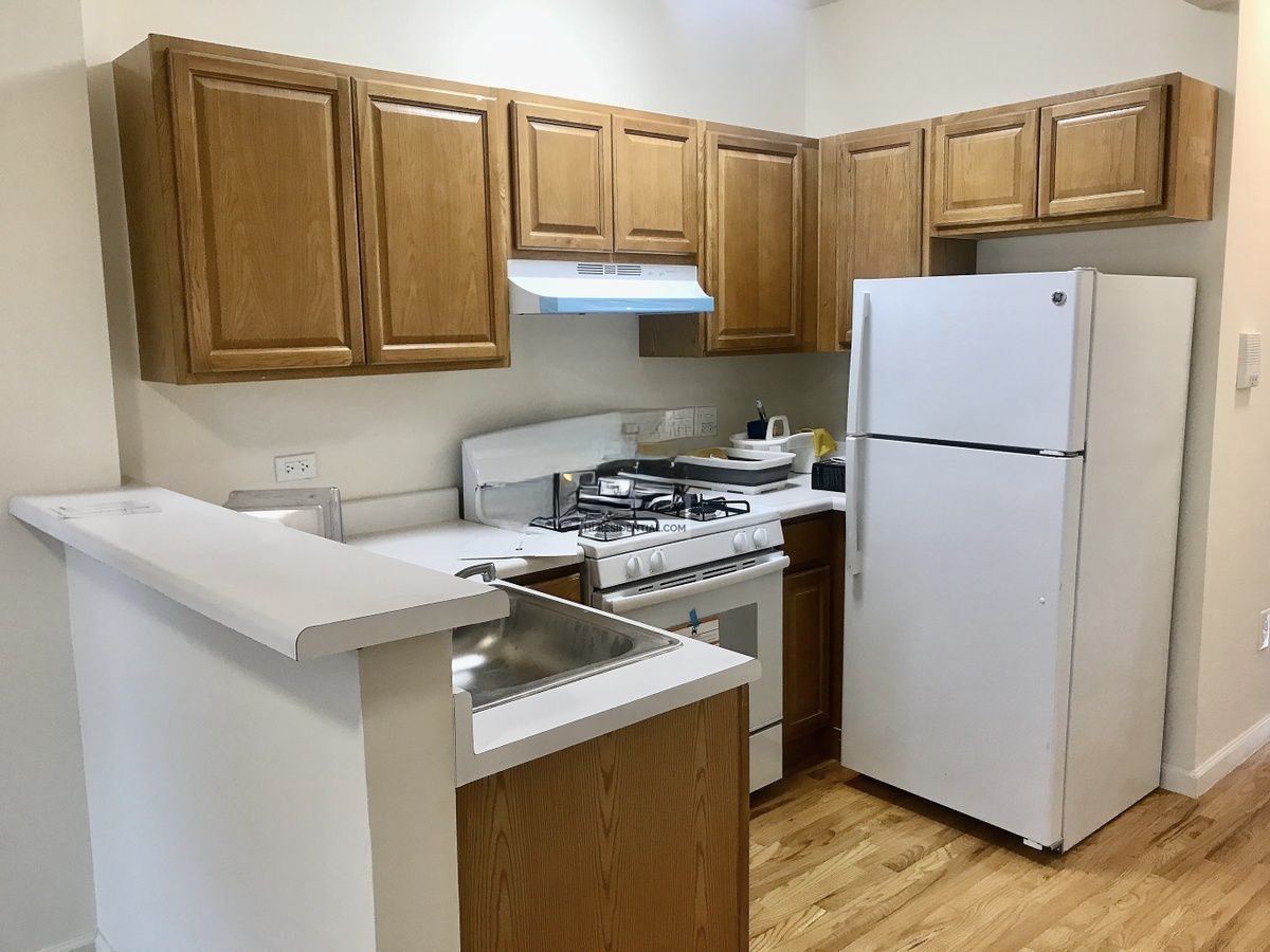 Convent Avenue Manhattan, NY 10031 - Photo 3 of 12 a kitchen with a refrigerator sink and cabinets