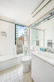 a bathroom with a sink a toilet a mirror and a shower