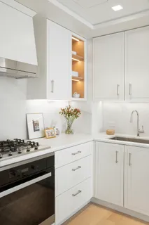 a kitchen with granite countertop white cabinets and a stove
