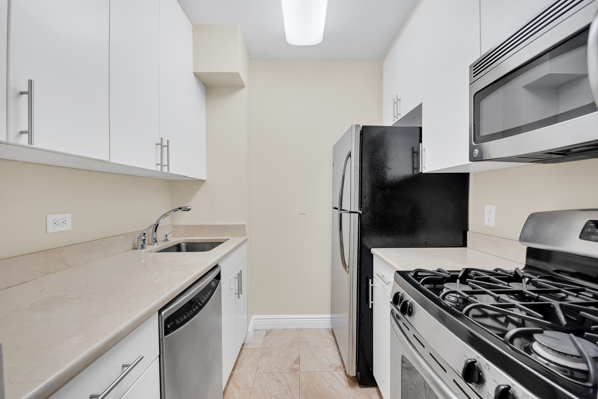 30 West 63rd Street, Unit 7O Manhattan, NY 10023 - Photo 3 of 16 a kitchen with stainless steel appliances a sink stove and refrigerator