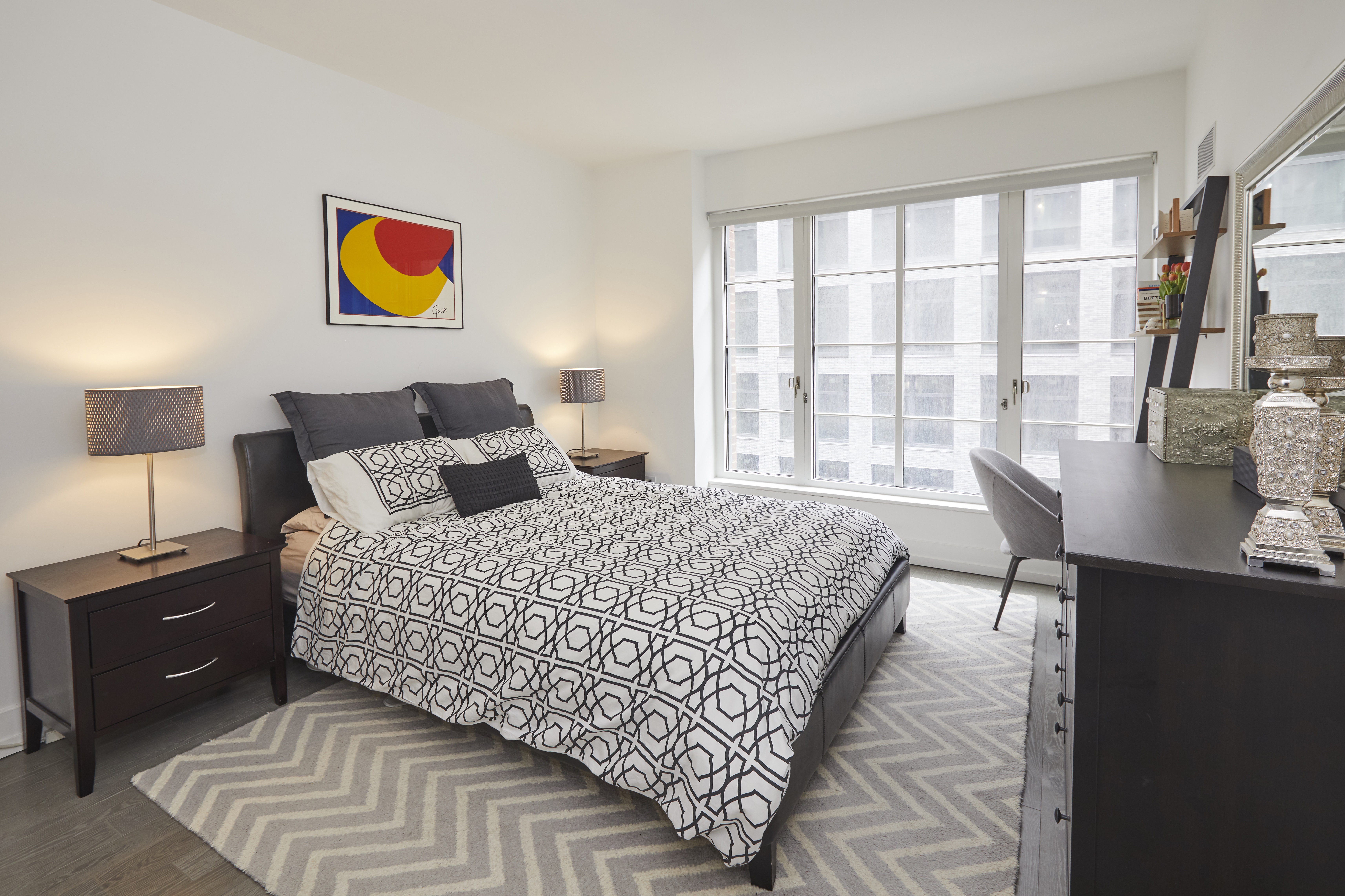 70 Charlton Street, Unit 7E Manhattan, NY 10014 - Photo 3 of 17 a bedroom with a bed and wooden floor