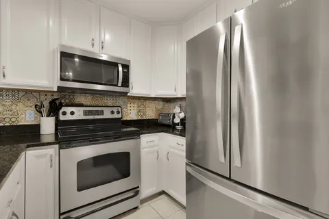 a kitchen with stainless steel appliances granite countertop a sink and a stove