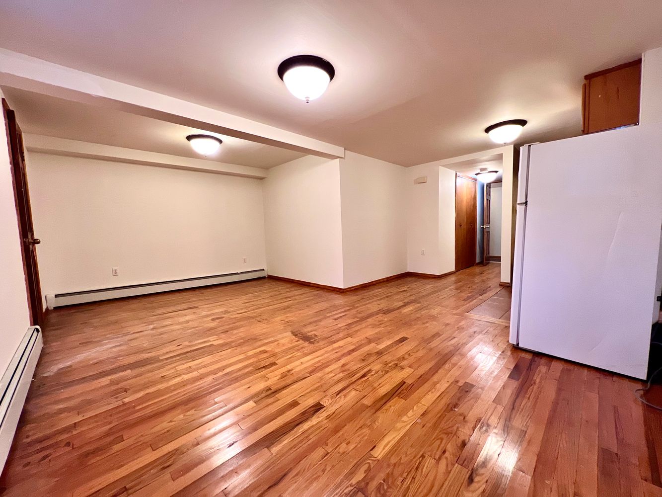 1561 Carroll Street, Unit Undisclosed Brooklyn, NY 11213 - Photo 3 of 9 a view of an empty room with wooden floor and a window