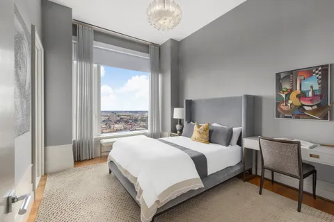 a bedroom with a bed and a large window