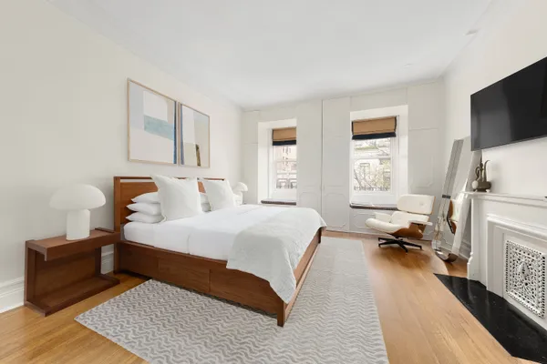 a bedroom with a bed and a flat tv screen on a dresser