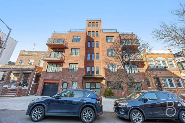 a front view of a residential apartment building with a parking space