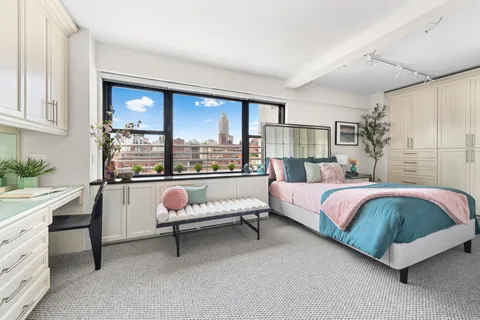 a bedroom with a bed chair and window